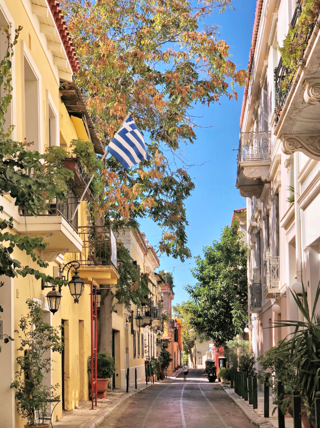 Beautiful street in Greece with balconies and trees.